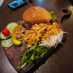 Pan con bistec, papas fritas y vegetales.