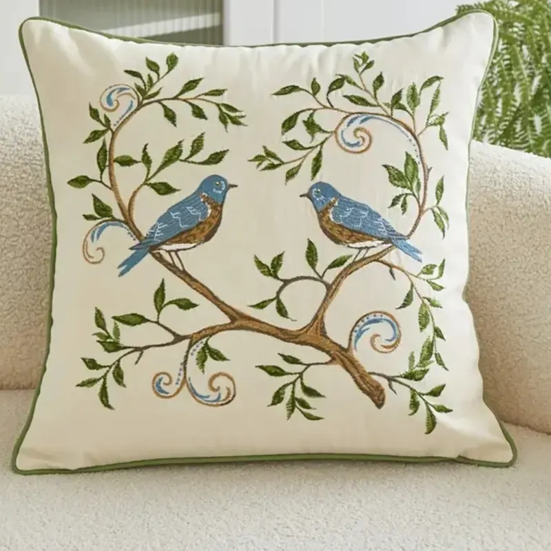 Cojin pareja de pájaros bordado con rivete en verde.