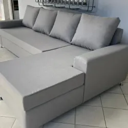 Sofá gris claro de tres plazas y chaise longue integrado