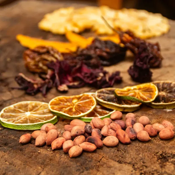 En DesNa transformamos frutas, especias, flores y vegetales frescos en productos deshidratados y de larga duración, manteniendo su sabor, aroma y valor nutricional. El proceso comienza con la cuidadosa selección de materias primas provenientes de productores locales, que luego se lavan, pelan y cortan para optimizar su secado. Posteriormente, se someten a un proceso de deshidratación mediante calor controlado y circulación de aire, eliminando el agua pero preservando sus propiedades esenciales, para finalmente envasarse de forma hermética y así garantizar su frescura. Esta técnica conserva hasta el 90% de los nutrientes, prolonga la vida útil sin necesidad de conservantes químicos, facilita el transporte y almacenamiento, y reduce el desperdicio alimentario. Nuestros productos pueden disfrutarse como snacks saludables listos para consumir, en infusiones y tés, en repostería y cocina gourmet, como complemento en coctelería o como ingrediente en mezclas de cereales y granolas, ofreciendo siempre una experiencia auténtica y de calidad en cada bocado.