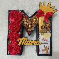 Caja en forma de letra con confituras y flores