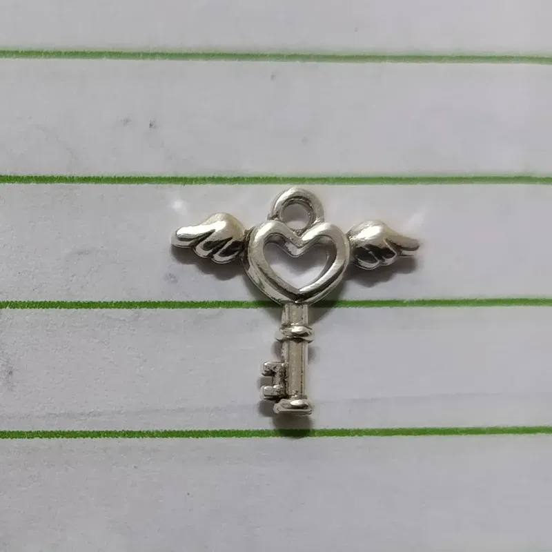 Dije en forma de llave con alas