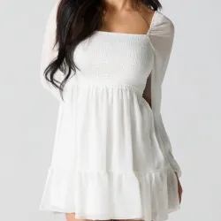 Vestido blanco corto con mangas largas.