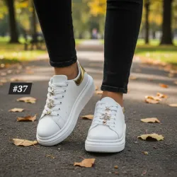 Tenis con detalles dorados en las tiras.