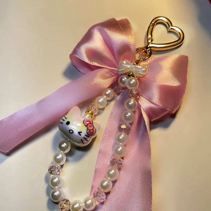 Colgante con lazo rosa , charm en cerámica y broche dorado en corazón 