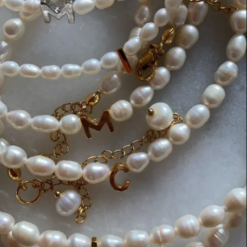 Collar de imitación de perlas de rio con letra dorada 