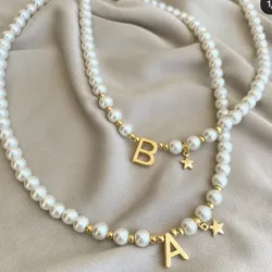 Collares de perlas blancas coco con letra dorada .