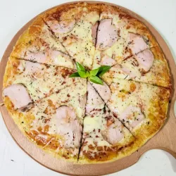Pizza de la casa con jamón curado.