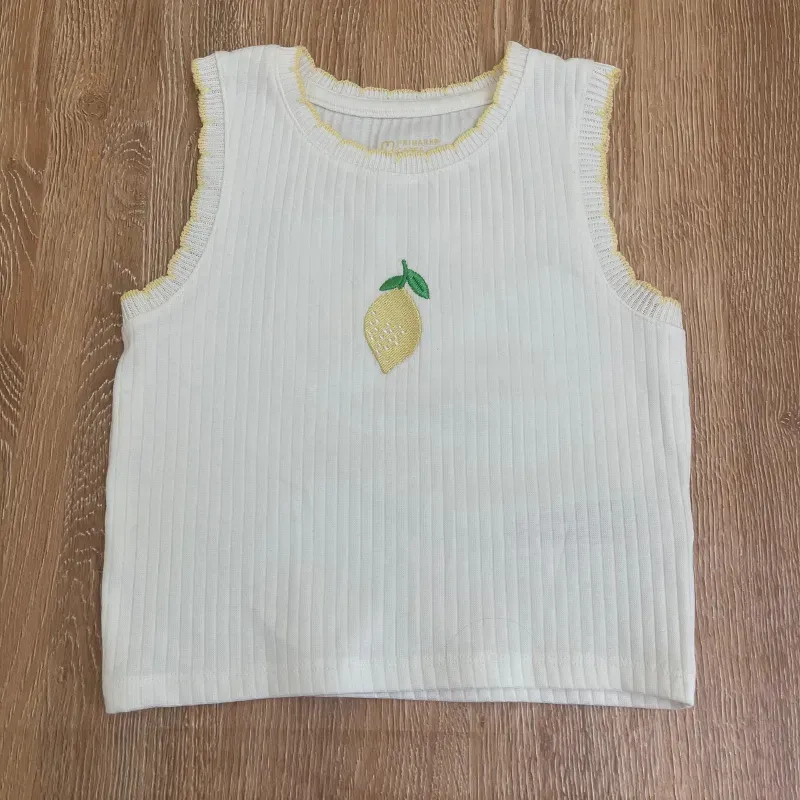 Conjunto color amarillo y blanco con limón en el centro 