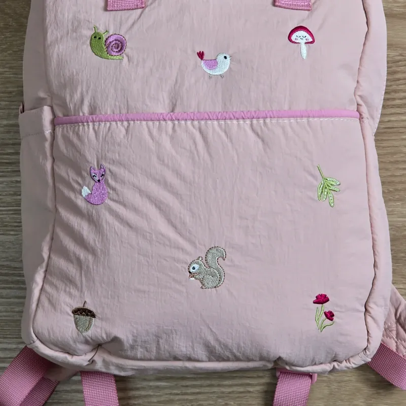 Mochila rosa con detalles bordados