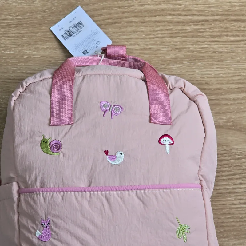 Mochila rosa con detalles bordados