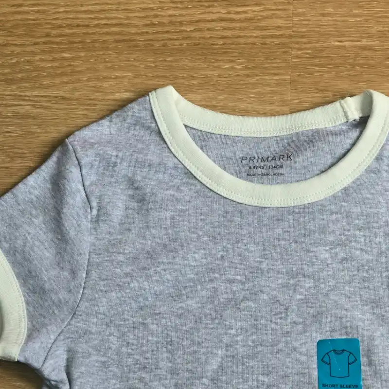 Pulover color gris con bordes blancos