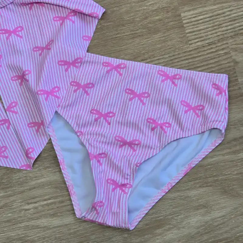 Traje de baño rosa con lazos con detalle de flor dorada