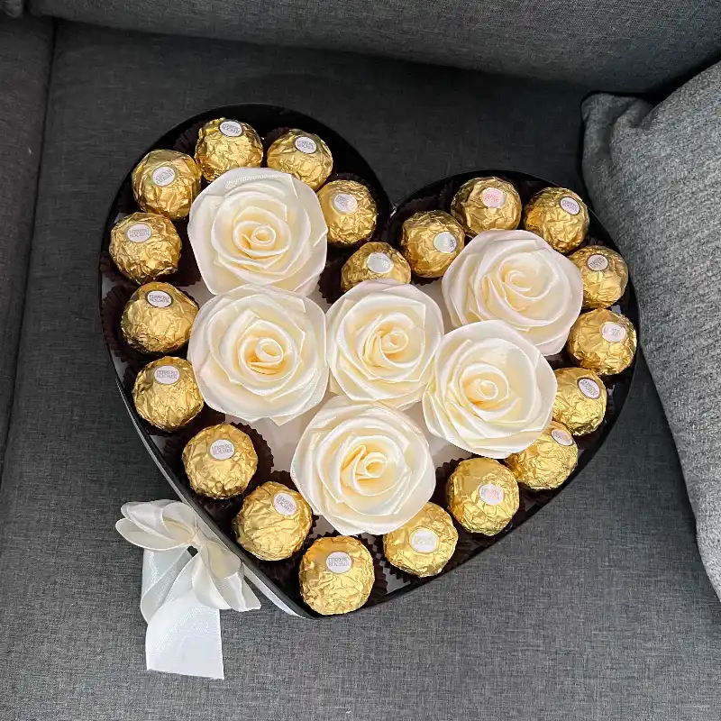 Caja con rosas y bombones por los bordes 
