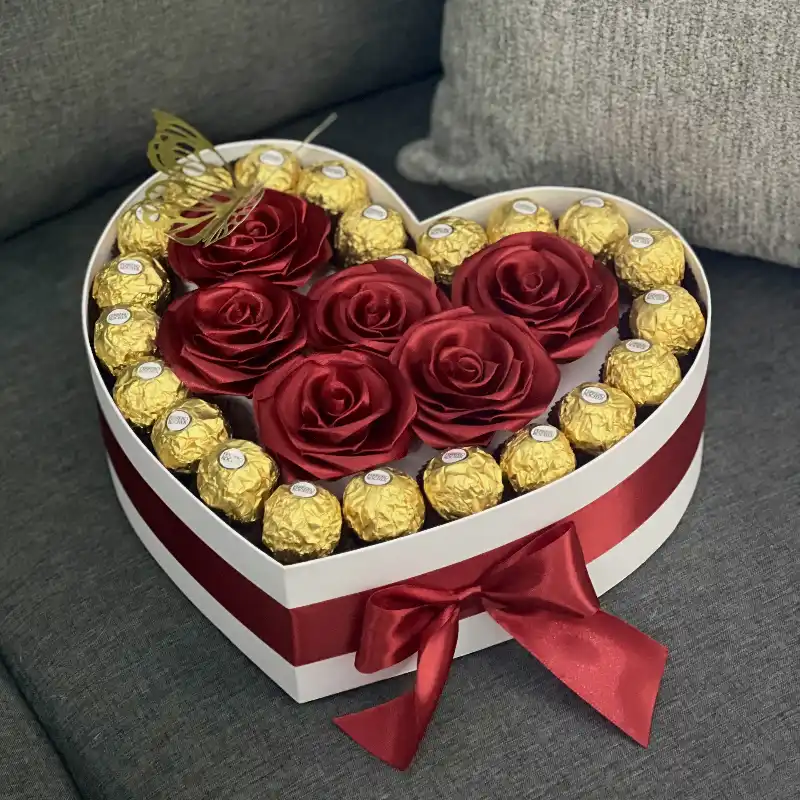 Caja con rosas y bombones por los bordes 