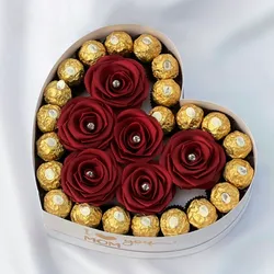 Caja con rosas y bombones por los bordes 