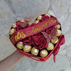 Corazón con cintas, flores y bombones