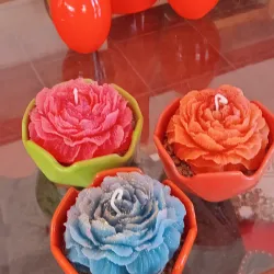 Vela en forma de flor de poenia grande con base de ceramica